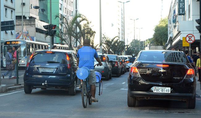 FERNANDO PRIAMO/26-07-16 Apesar de sinalização indicar que ciclista deve circular à direita, homem se arrisca no meio de carros